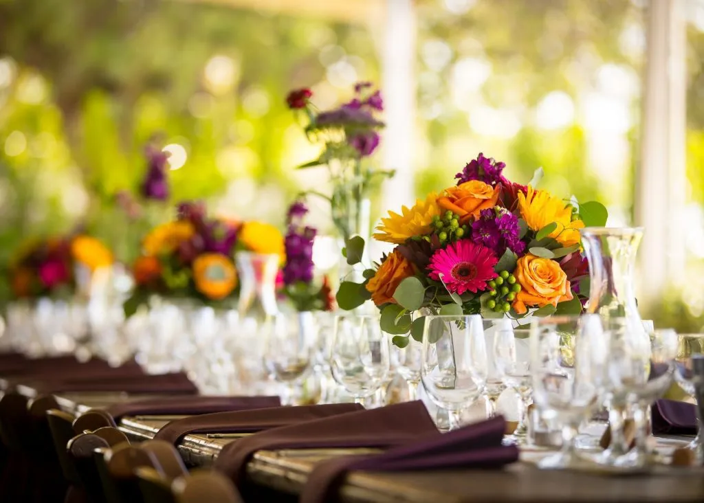 tables with glass and flowers on it